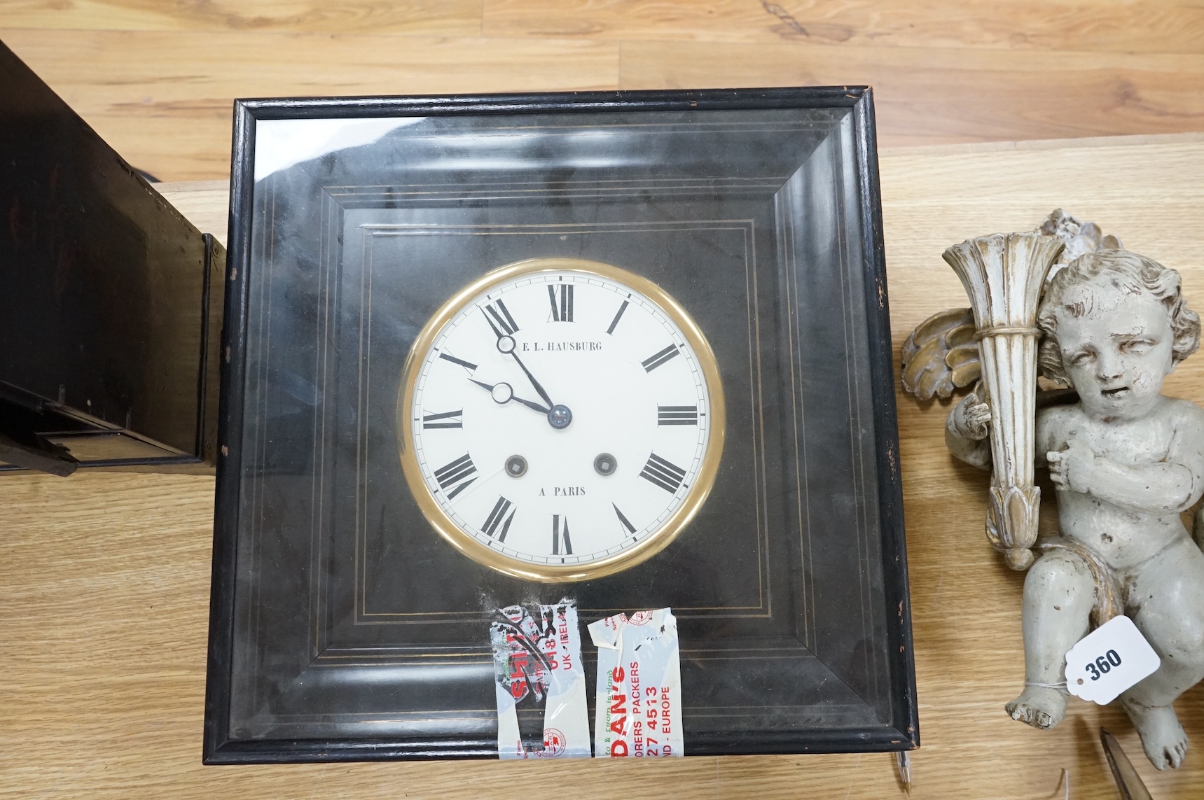 A Japanese lacquer table cabinet with inset porcelain panels, the drawers filled with sundry objects, clay pipes, decanter stoppers, etc, together with a black japanned wall clock, the dial inscribed F. L Hausburg, Paris